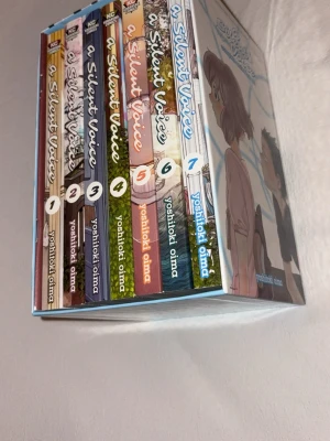 A Silent Voice boxset manga 1-7 - Säljer en komplett box med manga-serien A Silent Voice, volym 1 till 7, skapad av Yoshitoki Oima. Boxen har färgglada omslag med anime-inspirerade illustrationer och kommer i en snygg pappbox med motiv från serien. Perfekt för dig som gillar känslosamma berättelser och manga.