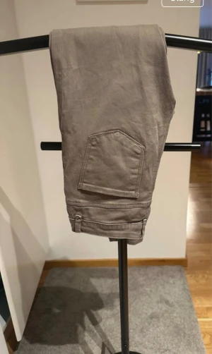Khakifärgade slim fit byxor - Snygga khakifärgade slim fit byxor. Klassisk femficksmodellt med knapp och dragkedja fram. Perfekta för dig som vill ha en clean och stilren look.