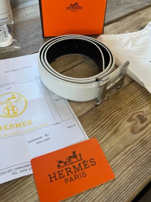 Skärp med H spänne - Säljer detta vita skärpet, allt på bilderna följs med, box, dustbag, kvitto, kort och såklart skärpet. Tveka inte på att höra av er vid fler frågor eller bilder🚨Pris kan även diskuteras 
