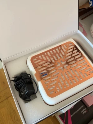 Nageldammsugare Blueque roséguld - Snygg och modern nageldammsugare från Blueque i vitt och roséguld. Utrustad med LCD-display, stark fläkt och laddningsbar funktion. Perfekt för att hålla nagelplatsen fri från damm under manikyr och nagelförlängning. Levereras med laddare.