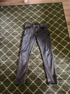 Gråa jeans från Armani - Snygga gråa jeans från Armani med klassisk femficksmodell och raka ben. Jeansen har en tvättad look och är tillverkade i mjukt denimtyg. Perfekta för dig som gillar stilrena och tidlösa plagg.