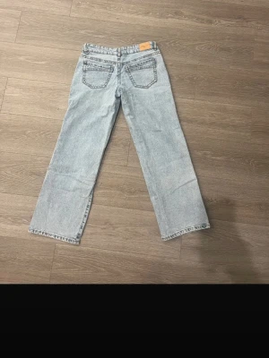 Ljusblå raka jeans  - Säljer ett par ljusblå jeans med rak passform och klassisk femficksdesign. Jeansen har en avslappnad look och är tillverkade i slitstark denim. Perfekta för dig som gillar en tidlös och enkel stil.