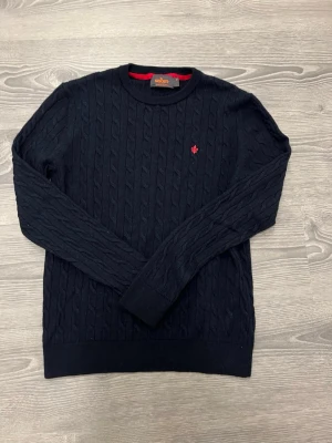 Mörkblå kabelstickad tröja Morris - Mörkblå kabelstickad tröja från Morris. Tröjan är i jättebra skick. Morrisen är i storlek M men sitter som en XS. Priset är ej hugget i sten och det är bara att hör av sig vid fundering.