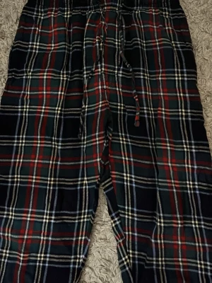 Rutiga pyjamasbyxor med dragsko - Mysiga pyjamasbyxor i klassiskt rutigt mönster med färgerna mörkgrön, röd, vit och svart. Byxorna har elastisk midja och dragsko för skön passform. Perfekta för chillkvällar hemma. Jag är verkligen inte säcker på storlek för det står inte, men jag vet att det är barnstorlek så ca 148-155 och storleken i barn är då storlek: (S)
