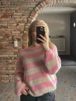 Rosa och vit randig stickad tröja - Säljer en oversized stickad tröja med breda rosa och vita ränder. Tröjan har en lös passform, långa ärmar och bred halsringning så ser väldigt snyggt ut off shoulder. Storlek xs/s, knappast använd 🌸