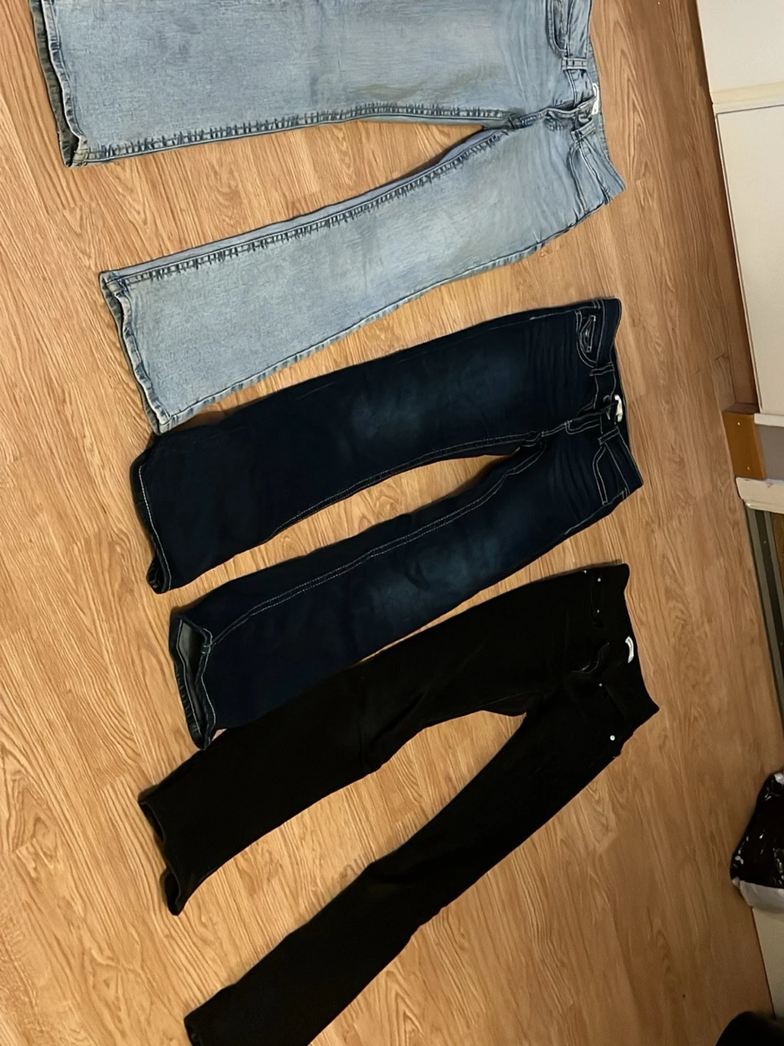 Tre par bootcut jeans i olika färger