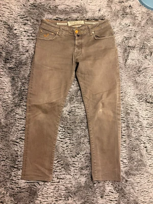 Gråa jeans från jacob cöhen - 101/44 Snygga gråa slim fit jeans från Jacob cöhen med klassisk femficksdesign och guldfärgade detaljer. Jeansen har en rak passform och är tillverkade i mjukt bomullsmaterial med stretch för extra komfort. Perfekta för en avslappnad och trendig look.