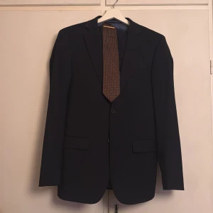 Mörkblå kostym med kavaj och byxor - Snygg blå wool strech kostym från dressman storlek 46 klassisk kavaj med matchande byxor och väst. Använd endast 2-3 gånger slips följer ej med 