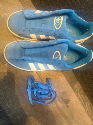 Blå Campus 00 - Säljer ett par blå Adidas Campus sneakers, storlek 38 2/3. Använda men frf fint skick. Vet ej om snörena är de originella. 💕