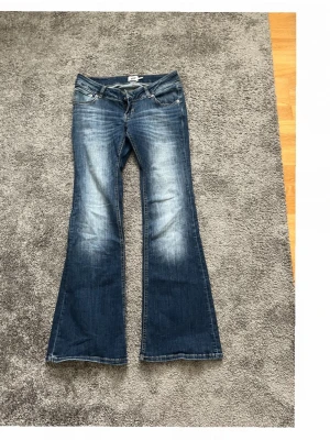 Blå bootcut jeans med utsvängda ben - Säljer ett par lågmidjade blå bootcut jeans från Lager157 då dem inte kommer till använd alltså är de intill helt nya🙌🏻 Dem är i stolek L men passar även M, skriv om ni undrar något❤️