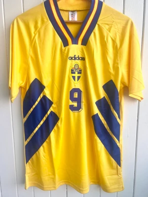 Jonas Thern. - Sverige - VM 1994 - Säljer en klassiska fotbollströja, Jonas Therns svenska hemmamatchtröja från VM 1994 i USA. Tröjan är en reprint i nyskick.  Aldrig använd.  Storlek: Medium