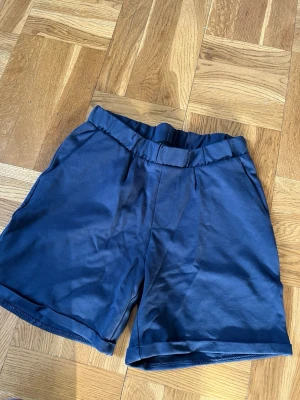 Mörkblå shorts med resårmidja - Helt nya mörkblå shorts med resår i midjan och uppvikta benslut. Sköna som mjukis shorts men funkar även till vardags. Säljer dom för 50kr, nytt pris är 100kr.