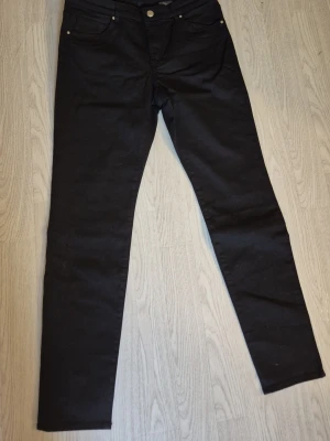 Svarta skinny jeans Strl 40P - Svarta skinny jeans med klassisk femficksdesign och smal passform. Jeansen har normal midja och stängs med dragkedja och knapp. Från H&M storlek 40P. Små i storleken. Katt finns I hemmet