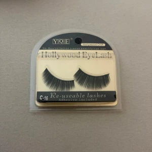Hollywood EyeLash lösögonfransar - Säljer ett par svarta, täta lösögonfransar från YQE i modellen Hollywood CHA. Fransarna är böjda och ger en dramatisk look. Förpackningen innehåller lim och fransarna är återanvändbara. Perfekt för dig som vill ha extra volym till ögonen.
