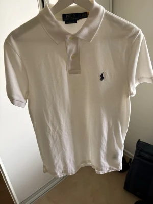 Ralph Lauren Piké - Säljer min vita Ralph Lauren piké då den bara används två gånger och därav kommer den till försäljning. Den har inga defekter eller märken. Den är som sprillans ny. Hör av dig vid funderingar!
