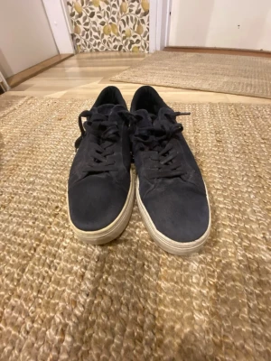 Blåa vagabond  - Snygga blåa sneakers med klassisk låg profil och vit sula. Skorna har ovandel i mockaliknande material och matchande svarta skosnören. Perfekta för en clean och stilren look till vardagsoutfiten.