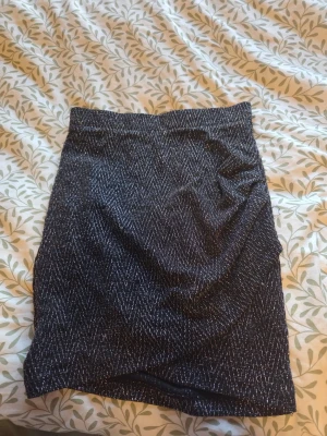 Svart glittrig kortkjol från ONLY - Säljer en svart glittrig kortkjol från ONLY i storlek XS. Kjolen har en rak passform och är täckt av tunna glittriga detaljer som ger ett snyggt skimmer. Perfekt för dig som vill sticka ut lite extra.