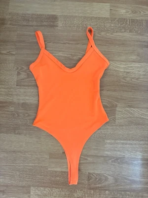 Orange body med v-ringning - Orange body, perfekt nu till sommaren och använt bara 1-3 gånger. Skickas inom 1-2 dagar