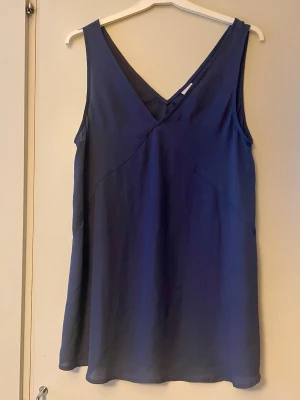 Blått längre linne i stl 36 fr Gina Tricot  - Använt enstaka gång. Inget att anmärka på. V-ringning både fram och bak, loose passform som ger en avslappnad och stilren look. Tillverkad i ett lätt syntetmaterial som faller snyggt.