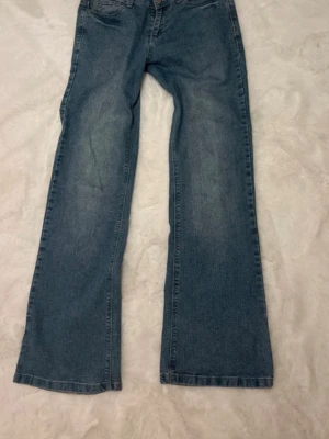 Blå bootcut jeans - Säljer ett par blå bootcut jeans. Dom är i skicket nytt och inga tecken på användning. Säljer pågrund av att dom inte passar 
