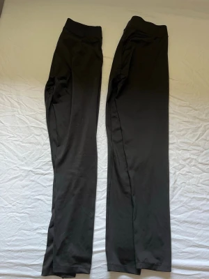 2 par svarta leggings med hög midja - 2 par svarta leggings med hög midja och smal passform. Mjukt och stretchigt material som sitter skönt mot kroppen. Perfekta till oversized tröjor eller hoodies. Klassisk modell utan synliga detaljer eller loggor. Båda är i storlek M!