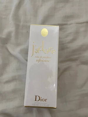 J'adore Infinissime Eau de Parfum Dior 100ml oöppnad  - J'adore Infinissime Eau de Parfum från Dior i elegant vit och guld förpackning. Flaskan rymmer 100 ml och doften är känd för sin blommiga och sensuella karaktär. Lyxig design med gulddetaljer och klassisk Dior-logga på toppen av kartongen. Oöppnad pris kan diskuteras 