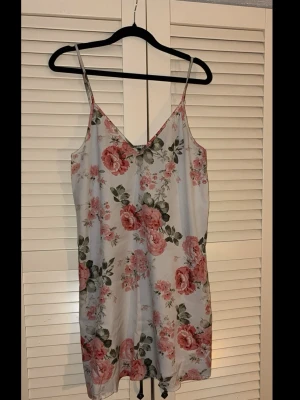 Blommig slip dress | Storlek S - 💕30% bundlerabatt vid köp av minst två artiklar.  🌸 Lätt och sval slip-klänning med smala axelband och V-ringning. Ljusblå bas med mönster av rosa och röda rosor med gröna blad.  ✔️Märke: Shein                                                         📏 Storlek S                                                               ⭐️ Fint begagnat skick. Hel och ren utan fläckar, hål eller andra synliga brister.