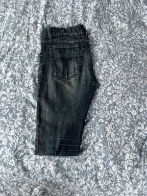 Mörkblå skinny jeans med slitningar - Säljer ett par mörkblå skinny jeans med snygga slitningar och tvättade detaljer. Jeansen har klassisk femficksmodell, låg midja och smala ben. Perfekta för dig som gillar en tight passform och en trendig look.