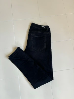 Svarta ursnygga dondup George jeans w35 - Superfina snygga eleganta och eftertraktade svarta Dondup George jeans i w35 (45 cm breda och 105 cm total längd). Väldigt prisvärda och brutalt schysst tvätt i utmärkt skick! Tveka inte vid minsta fråga eller fundering och pris ej hugget i sten.