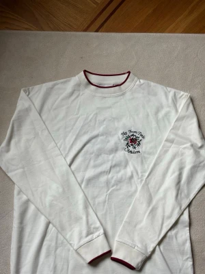 Vit långärmad tröja Not From Paris - Vitröd lång sleeve från Not from Paris Madame, den är helt ny men är fel storlek på mig. Helt nytt skick, väldigt snygg och ska sitta lite baggy.