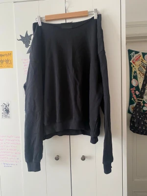Svart off shoulder sweatshirt  - En enkel svart oversized hoodie med långa ärmar och bred mudd vid ärmslut och nederkant. Hoodien har en avslappnad passform och är tillverkad i mjukt bomullsliknande material. Perfekt för en chill och casual stil.
