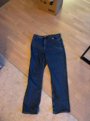 Blå raka jeans från ASOS DESIGN - Säljer ett par klassiska blå jeans från ASOS DESIGN med rak passform och hög midja. Jeansen har fem fickor, gylf med dragkedja och knapp samt kontrastsömmar. Perfekta till en avslappnad stil och tillverkade i slitstarkt denimtyg.