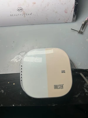 Elfil Nailster - Elektrisk nagelfilmaskin från Nailster i en fin champangerosa och vit färg, modell JMD-108. Maskinen har en stilren design i vitt och beige med rundade hörn. Den har en effekt på 30W och klarar upp till 35 000 RPM. Perfekt för nagelvård och manikyr. Passar både hemma och i salong. Handstycket är helt bytt för ca 2 veckor sedan. Köptes för 1299 Priset går att diskutera 🩷