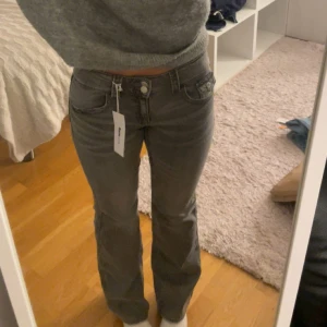 Gråa bootcut jeans från Gina Tricot - Säljer ett par snygga gråa bootcut jeans från Gina Tricot Young. Jeansen har hög midja, klassiska fem fickor och raka ben med lätt utsvängning. Materialet är mjukt denim med stretch för extra komfort. Perfekta för en trendig vardagslook! Storlek 164 men passar typ XS/S 💓💓💓