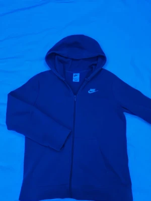 Blå Nike hoodie  - Säljer en blå Nike hoodie i väldigt bra skick jag är 175cm och den passar perfekt.