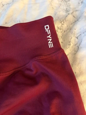 Vinröda seamless tights från DFYNE - Snygga vinröda tights från DFYNE i färgen winter berry😍Tillverkade i ett stretchigt material som passar perfekt för träning och gym. Knappt använda och är i storlek S🩷Nypris ca 600 kr