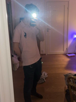 Ljusrosa pikétröja från Ralph Lauren - Aleles för stor darför jag säljer . Säljer en ljusrosa pikétröja från Ralph Lauren med klassisk krage och stor marinblå logga på bröstet. Tröjan har korta ärmar och är tillverkad i mjukt bomullsmaterial. Perfekt för en avslappnad och stilren look.