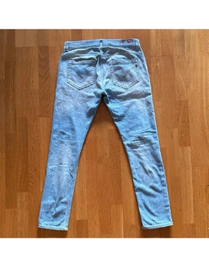 Ljusblå raka jeans - Säljer ett par ljusblå dondup jeans i modellen georg . Jeansen har en avslappnad look och är perfekta för en casual stil. Tillverkade i denim med snygga slitningar och ljus tvätt.