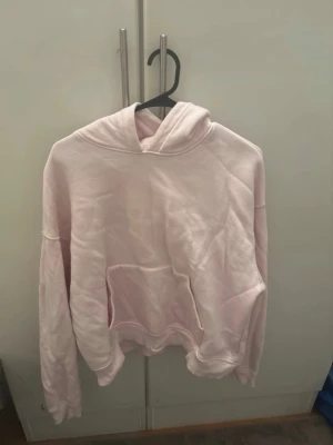 Ljusrosa hoodie med magficka - Säljer en ljusrosa hoodie med klassisk huva och stor magficka framtill. Hoodien har en avslappnad passform och ribbade muddar vid ärmslut och nederkant. Perfekt för en chill och bekväm stil. Materialet är mjukt och skönt, troligtvis bomullsblandning. För fler bilder/information skriv gärna, priset kan justeras 🤗❤️