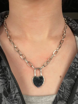 Kedje halsband med hjärthänglås - Säljer ett snyggt kedjeliknande halsband, knappt använd. Tyvärr är knäppet eller låset borta därav är det nedsatt pris. men har du ett lås hemma är det bara att sätta på. Skulle tippa på att den är köpt på guldfynd men inte helt säker. Kontakta om du har frågor eller är intresserad!