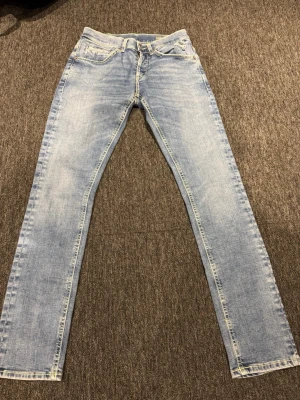 Ljusblå skinny jeans från Dondup - Snygga ljusblå skinny jeans från Dondup med klassisk femficksdesign och dragkedjedetaljer på bakfickorna. Jeansen har låg midja och är tillverkade i stretchigt denim för en bekväm passform.