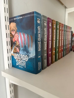 Vinland Saga bokserie 1-12 - Säljer hela Vinland Saga manga-serien, volym 1 till 12, av Makoto Yukimura. Böckerna har färgstarka omslag med olika nyanser och är i pocketformat. Perfekt för dig som gillar historiska äventyr och manga med vikingatema.