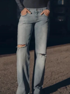 Zara jeans  - Säljer ett par populära skitsnygga, helt slutsålda jeans från zara. De är lågmidjade med vida ben och slitningar, endast använda 1 gång så nästan helt nya med perfekt skick.