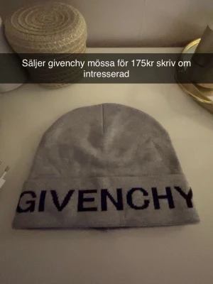 Grå Givenchy mössa  - Säljer en stilren grå mössa från Givenchy med stor svart logotyp broderad framtill. Mössan har klassisk form och är tillverkad i mjukt material som sitter skönt på huvudet. Perfekt för dig som vill ha en trendig accessoar med lyxig känsla.