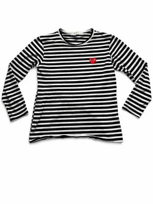 Comme des garçons - Snygg svartvit randig långärmad topp från Comme des Garçons Play med det ikoniska röda hjärtat broderat på bröstet. Tillverkad i mjuk bomull och har en klassisk rund halsringning. Perfekt för en trendig och avslappnad stil.