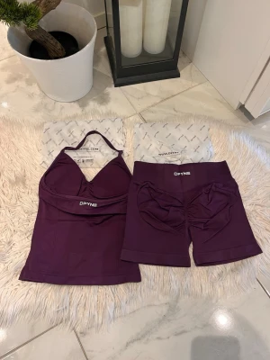 DFYNE - Snyggt lila träningsset från DFYNE med ett linne med smala axelband och vadderade kupor samt matchande shorts med scrunch-detalj bak. Setet är gjort i ett stretchigt och mjukt material som passar perfekt för gym eller yoga. Slutsåld på hemsidan , impact 4.5.
