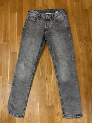 Grå jeans från Vailent - Snygga grå jeans från Vaillent med klassisk femficksdesign och raka ben. Jeansen har en tvättad look och är tillverkade i ett mjukt denimtyg som passar perfekt till vardagsstilen. Midjan har bälteshällor och stängs med knapp och dragkedja. W29 L30