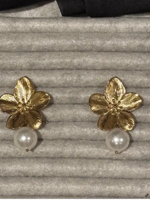 Guldiga blomörhängen med pärldetalj - Jätte coola och unika örhängen från Raglady! Använt dem max 3 ggr, därmed väldigt fint skick! Hör av er vid frågor 💕