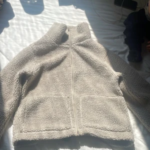 Beige teddyjacka från 157 XS💖 - Mysig beige teddyjacka från 157 i storlek XS. Jackan har hög krage, hel dragkedja framtill och två stora fickor. Finns ett litet hål på främsta fickan men det är pytte litet.