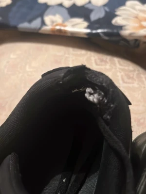 Svarta Nike Air sneakers med gulddetaljer - Svarta Nike Air sneakers med klassisk låg siluett och snygga guldfärgade loggor på hälen. Skorna har en sportig look med textil- och syntetmaterial samt snörning framtill. Perfekta för dig som gillar streetwear och vill sticka ut med stilrena detaljer.